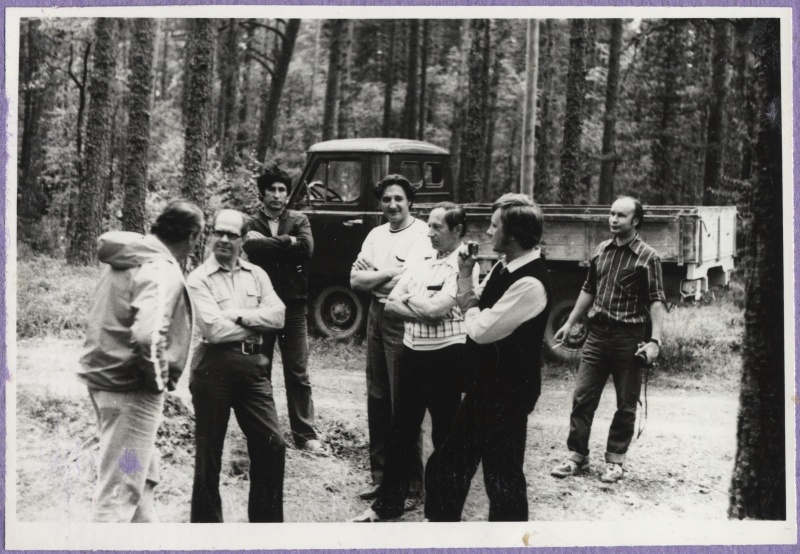 Haapsalu Kalakaitse Inspektsiooni töötajad väljasõidul. Esiplaanil grupp mehi metsalagendikul. Nende taga UAZ tüüpi veoauto.