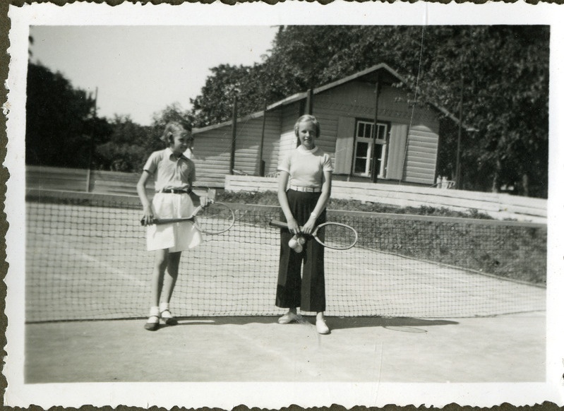 Niina Nurslandt sõbrannaga Kuressaare tenniseväljakul reketitega poseerimas.
