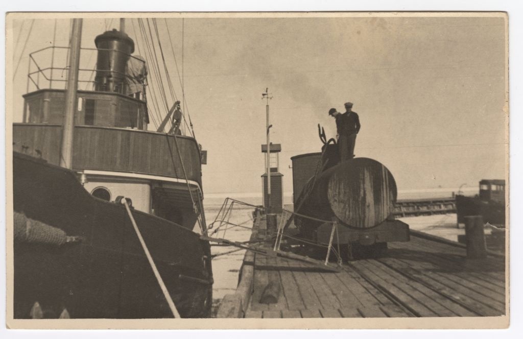 Jäämurdja-puksiir "Merikaru" Virtsu sadamas õli võtmas. Kail vagun tsisterniga, millest jooksevad voolikud laevale.