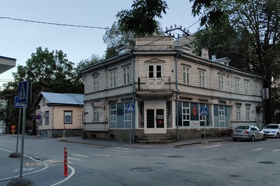 Sakala tn 19 puidust hoone, esiplaanil mantli ja karvamütsiga härra rephoto