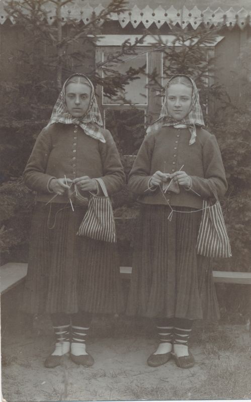 Foto. Kaks noort Vormsi neidu maja juures kudumas sukka, triibulised sukavarda kotid, u. 1930. Johanna Menerti kogu