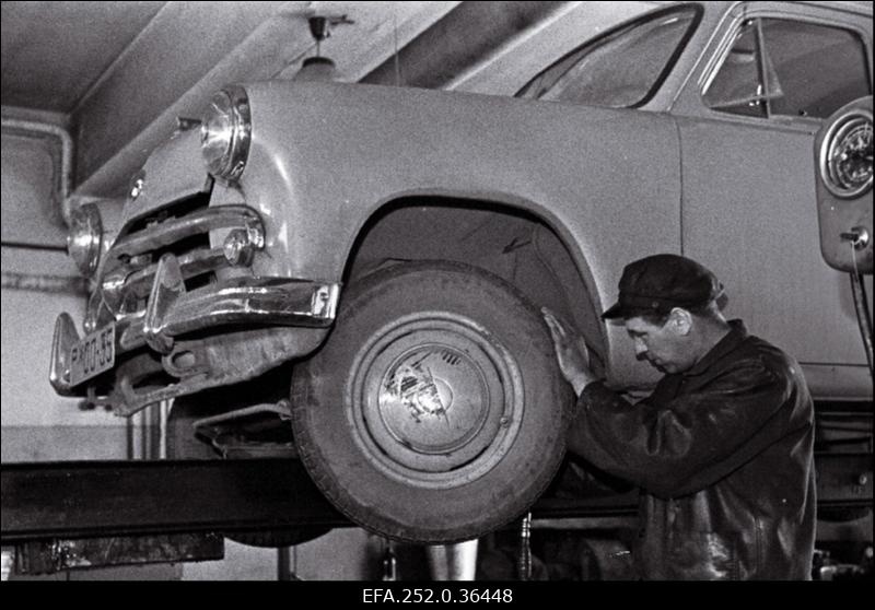 Tallinna Sõiduautode Pargi tehnilise teenindamise jaama autolukksepp-määrija Harri Kaseväli on ametis sõiduauto Moskvitš esisilla määrimisega.