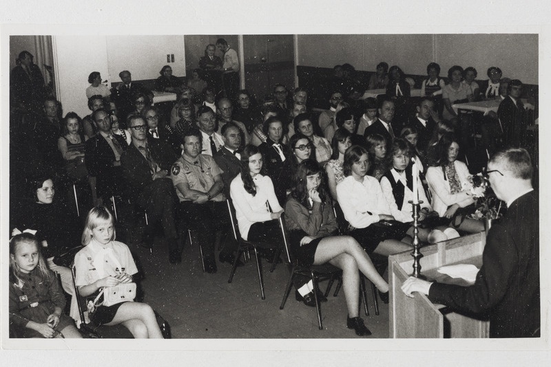 Skautide-gaidide aastakoosolek '71 Göteborgis Rootsis, mees kõnepuldis ja rahvas saalis.