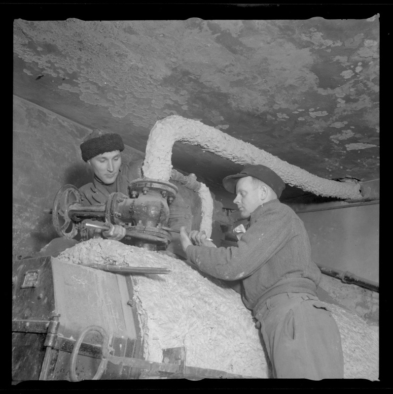 Töölised keskküttetoru ja peakraani ühendusmutreid keeramas