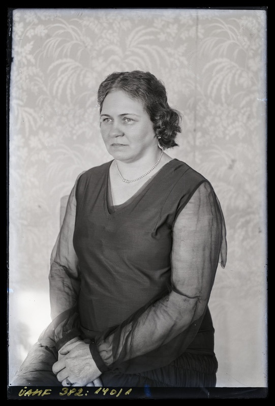 Naise portree, poolprofiilis, istumas.