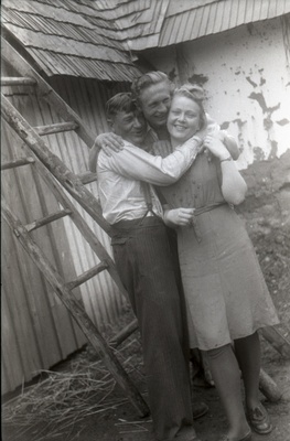 Mees ja naine seismas kuuri taustal, mees nende selja taga redelil (Rõngu kiriku leer)  similar photo