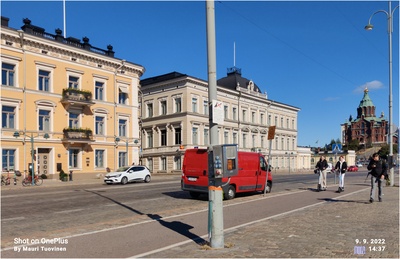 Elannon kuorma-autoja autotapahtumassa. Autojen kylkiin on maalattu numerot ja konepeltiin kiinnitetty teksti "aja varoen, aja oikein". Taustalla Pohjoisesplanadi 5 ja 3 sekä Uspenskin katedraali. rephoto