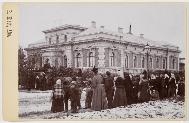 Ihmisiä arkkipiispantalolle kerääntyneenä; ulkokuva