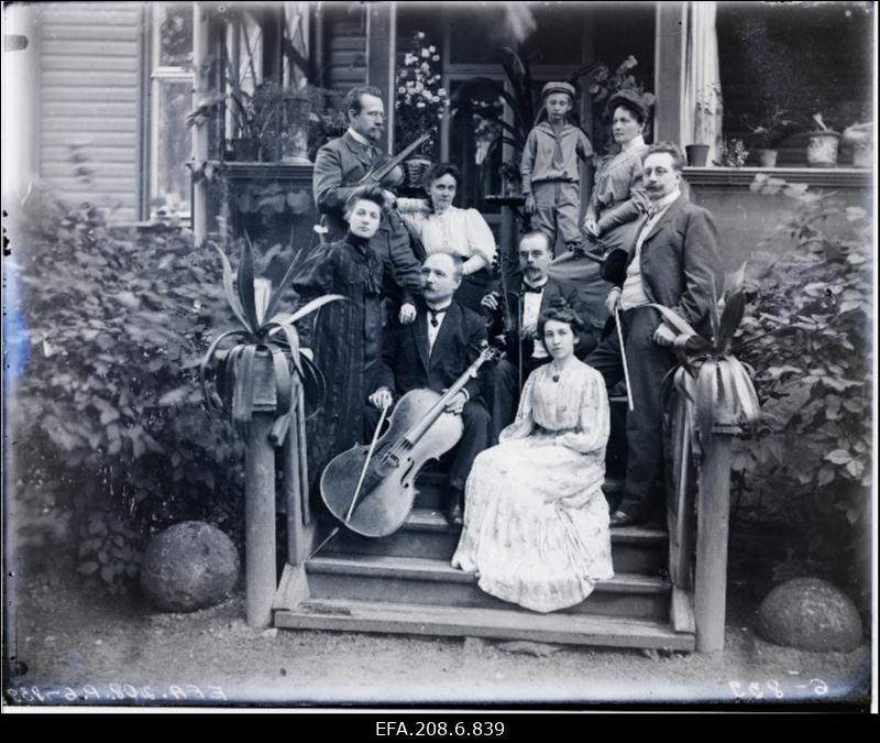Grupp inimesi muusikariistadega maja trepil.