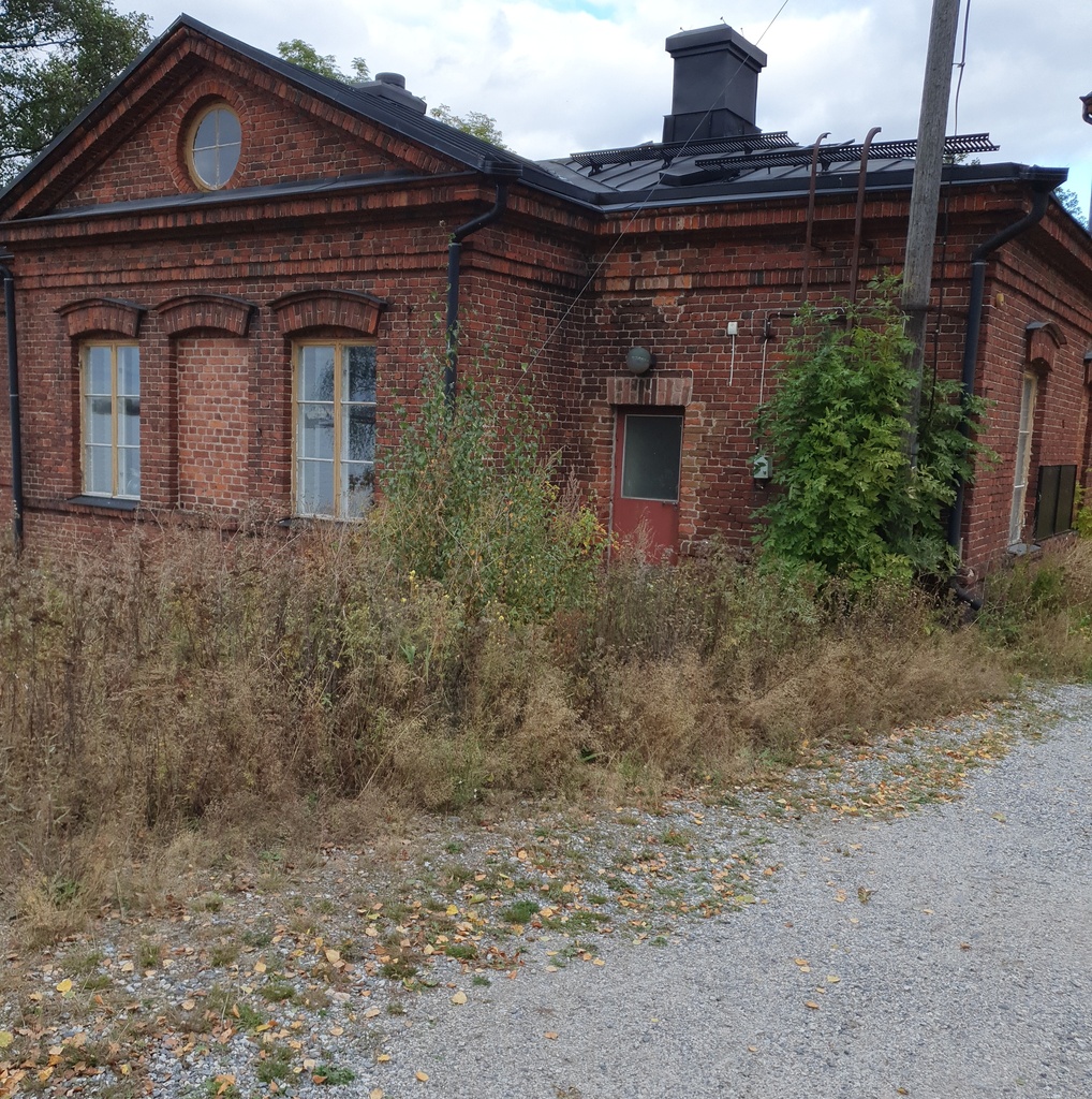 Vallisaarelaisia saaren luotsitalon pihapiirissä. Kaksi miehistä on sotilasunivormussa. Toisella naisista on sylissään pieni lapsi. Taustalla näkyvä tiilirakennus on luotsitalon sauna- ja pyykkitupa. rephoto