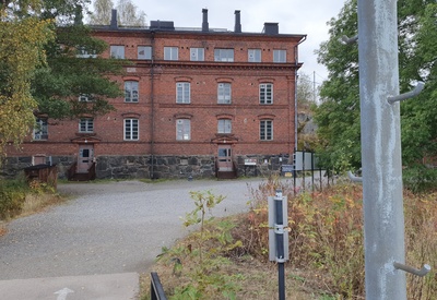 Vallisaaren luotsitalo päälaiturilta päin kuvattuna. Rakernnuksen edustalla oleva pieni puinen rakennus on vartiokoppi. Vallisaari oli pitkään ensin Venäjän armeijan varuskunta-aluetta, sitten itsenäistyneen Suomen armeijan aluetta, johon pääsy oli luvanvaraista. Vartiokopissa tarkastettiin kulkuluvat vielä 1960-luvun alkupuolella. rephoto