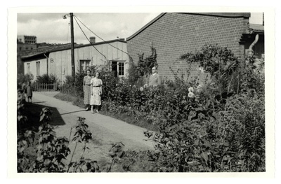 Hugo Kaho abikaasa ja tundmatu naisega aias barakkelamu taustal  similar photo