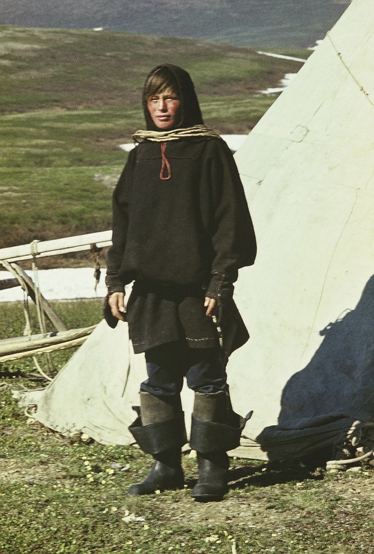 Handi mees, seljas umbkuub, jalas kummikud. Kaela ümber on lasso, millega püütakse põhjapõtru. 
Jamali autonoomne ringkond Priuralski rajoon Katrovoži küla  põhjapõdrakasvatajate ajutine suveasula Põhja-Uuralides.
Foto 1978.