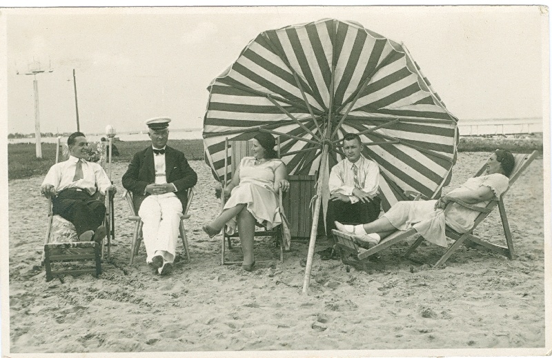 Foto. Suvitajad Haapsalus Aafrika rannas triibulise päikesevarju kõrval. 1930 ndad. O. Siluti kogu. Albumis.