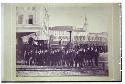 Tallinna raudteejaam, näha jaamahoone nurk ja vedur. Ees grupp inimesi, keskel Ch. Borchardt.  duplicate photo