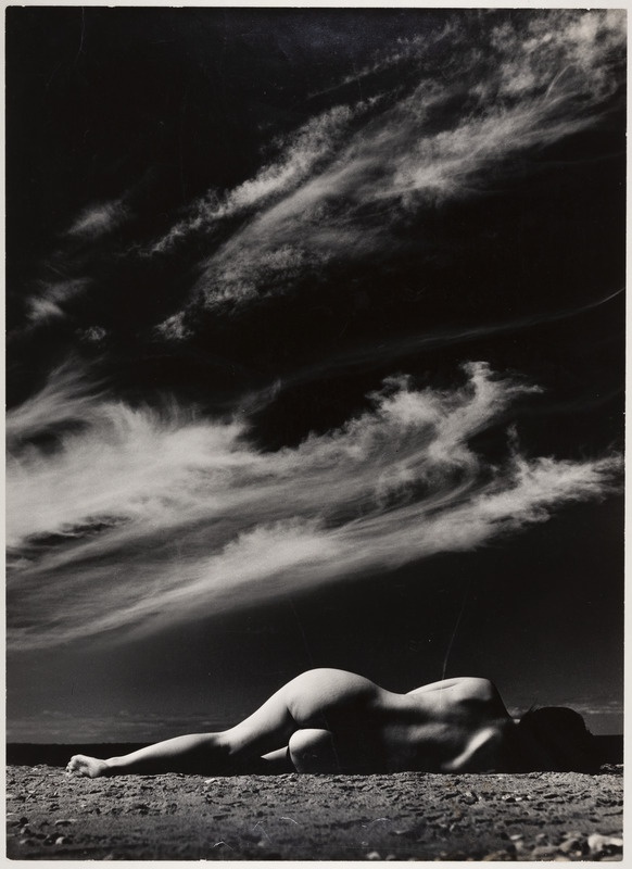 Taevas ja rannas küljel lebav akt.