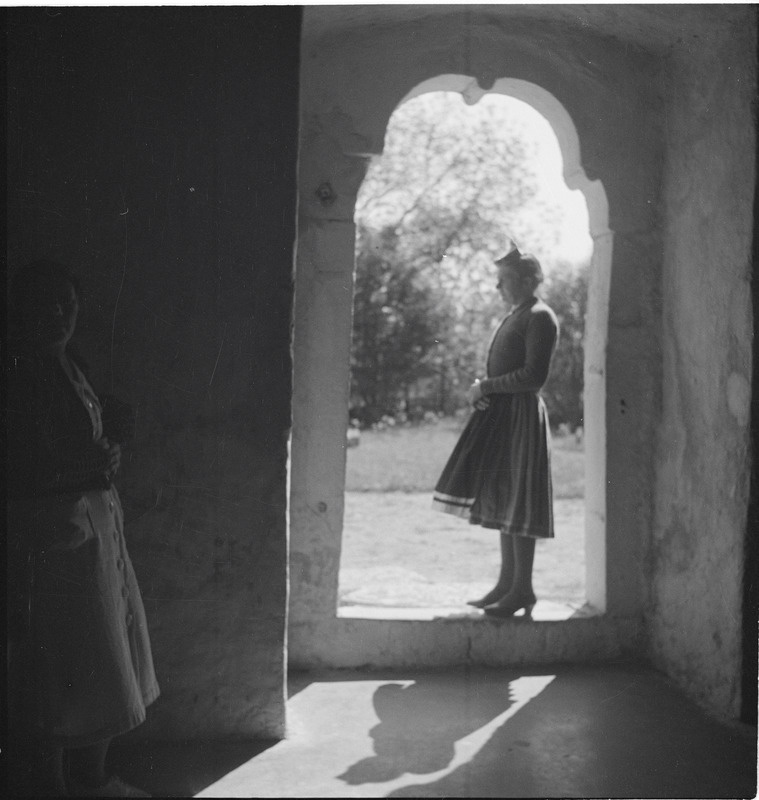 Muhu rahvariietes naine Muhu kiriku lõunaukse juures