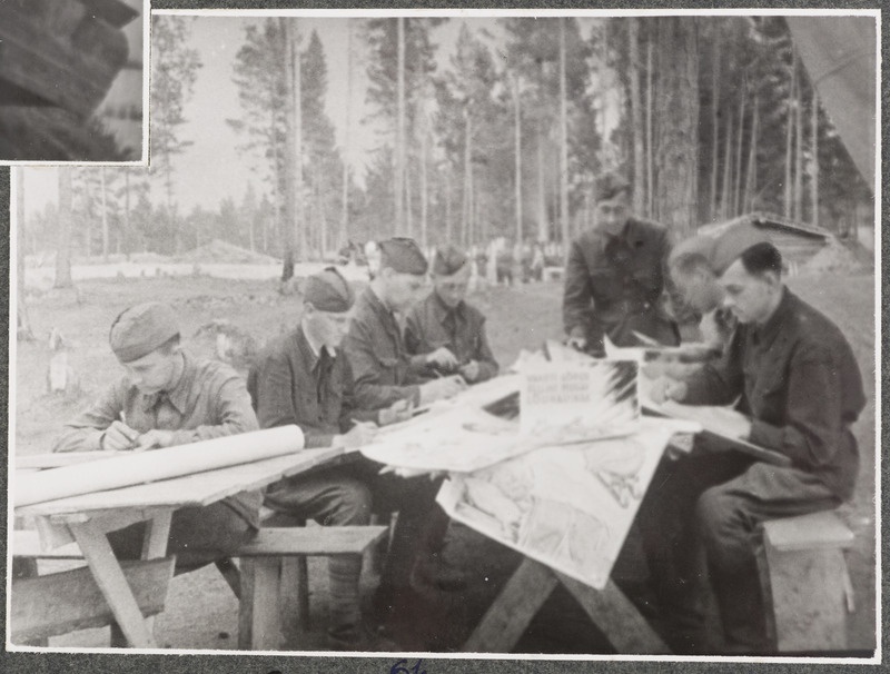 Kunstiline isetegevus laagris. Võitlejad on ametis seinalehe valmistamisega