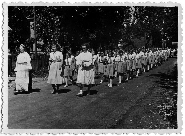 Kaelarättides koolitüdrukud (Jausa koolist) laulupeorongkäigus Kärdlas Vabaduse tänaval