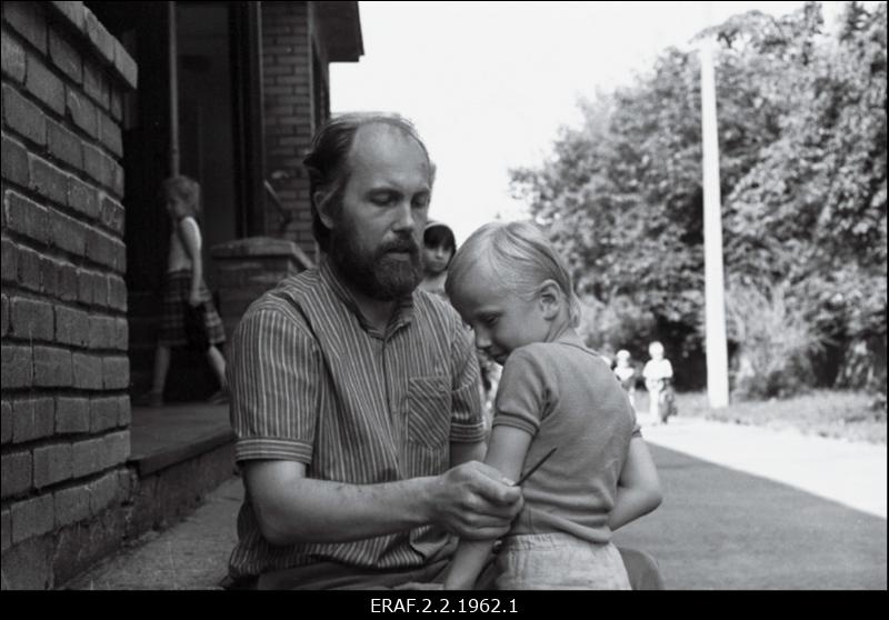 Tallinna Linnavalitsuse sotsiaalnõunik Tõnu Karu kükitab lapse kõrval