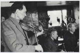 Mahtra Talurahvamuuseumi  kapel. Esiplaanil viiuliga Johannes Ausmees