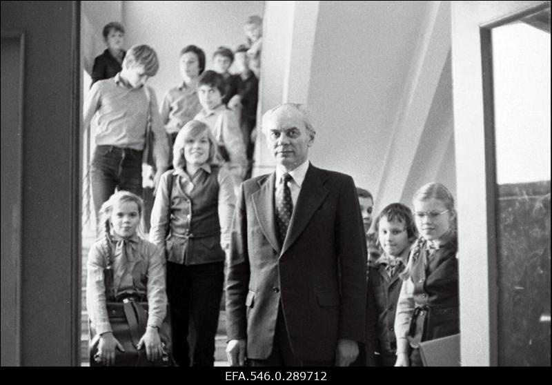 Õpetaja ja koolilapsed koolimajas trepil.