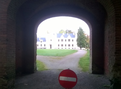 Alatskivi Manor Gate and Manor Building. In front of the brickstone wall and gate. See the main building behind the gate opening. rephoto