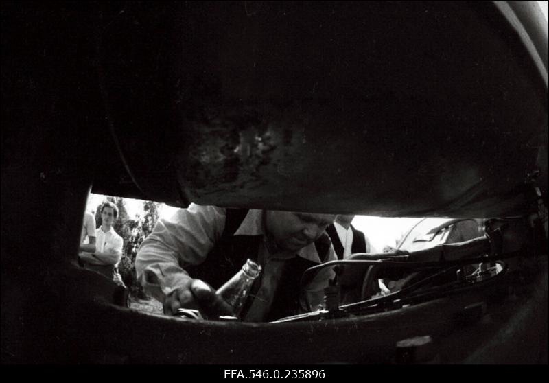 Lõikuspüha. Mees masinat putitamas.