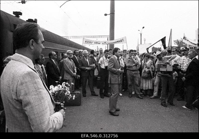 Eesti Rohelise Liikumise korraldatud loosungite-plakatitega rahvakogunemine Balti jaama perroonil Tallinn-Moskva rongi juures. Keskel Juhan Aare. [NSVL Rahvasaadikute nõukogu Eesti saadikute Moskvasse saatmise videosalvestus ETV Juhan Aare saatesarja "Panda" jaoks?]  similar photo