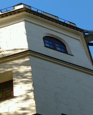 Akseli Gallen-Kallela on the tower of Tarvaspää working on a dragon-shaped gargoyle with his wife Mary watching, 1927. rephoto