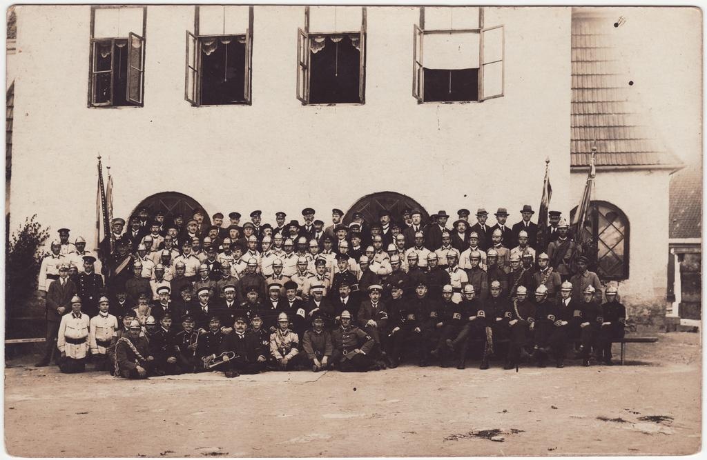 Kuressaare VTS liikmed nelja lipuga tuletõrjehoone ees