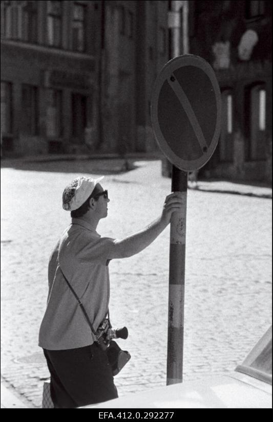 Turist fotoaparaadiga ja märk "peatumine keelatud".