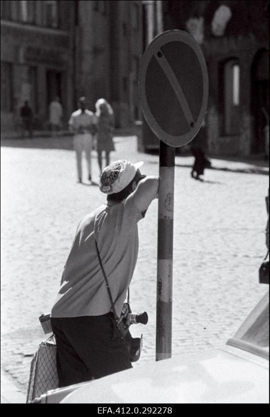 Turist fotoaparaadiga ja märk "peatumine keelatud".