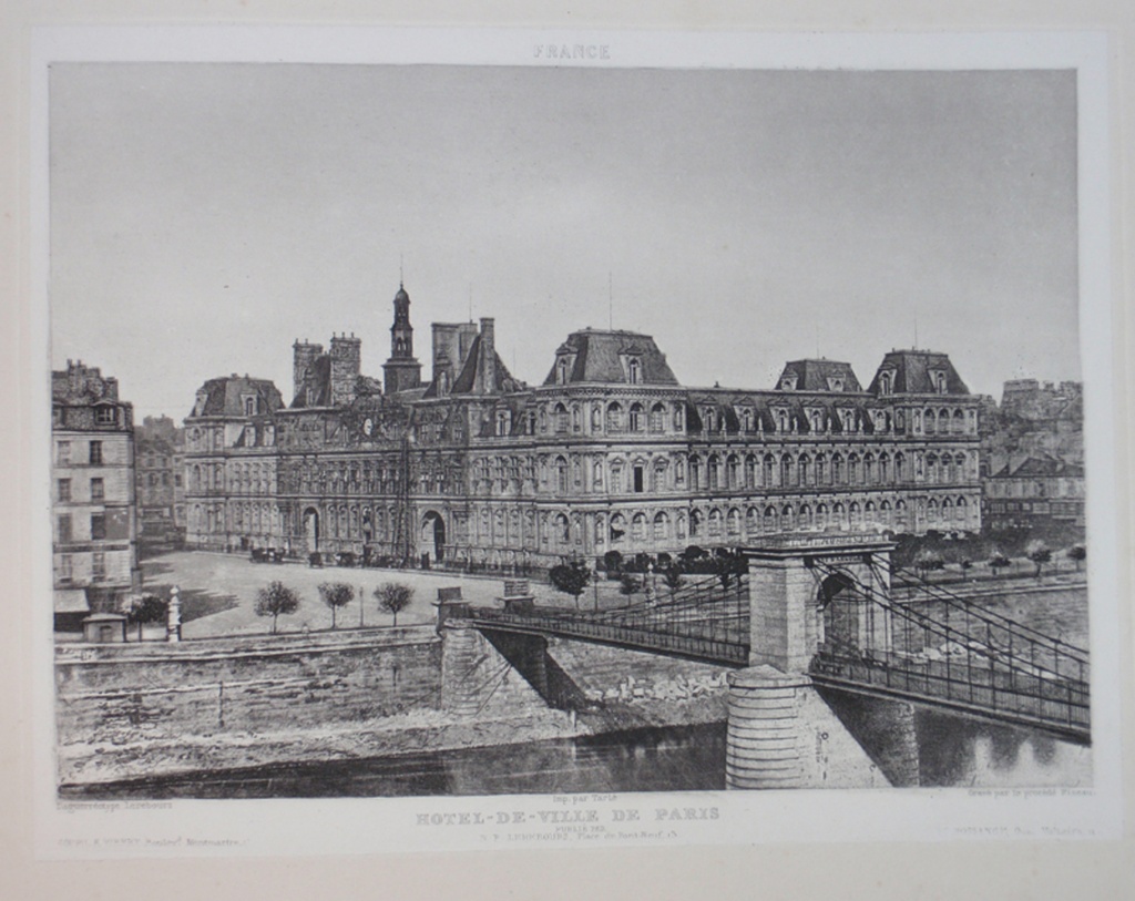 HOTEL-DE-VILLE DE PARIS - A view across a bridge and river of the Hotel de Ville in Paris, France.  Trees line the river, beyond which are buildings, carriages amd a seemingly empty street.