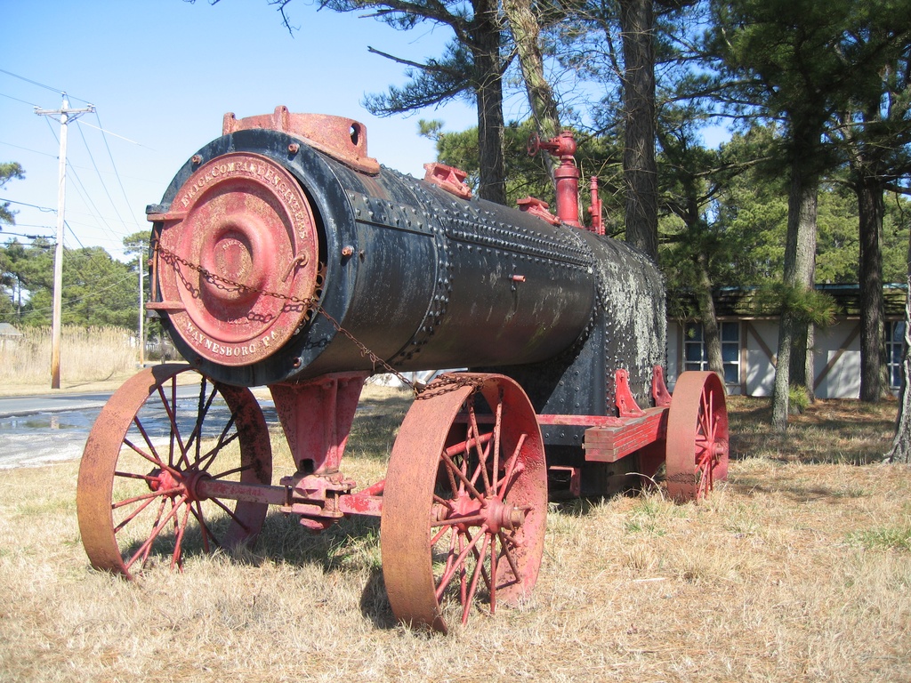 Frick Portable Engine 004 - Portable Steam Engine manufactured by Frick Company Engineers.  It is located at the "Y" intersection of Ridge Road and Bunting Road on Chincoteague Island, Virginia.  The address of the building next to this steam engine is 3625 Ridge Road.  The front end of the chassis has "Frick Company Engineers", "Patented Jan 10, 1882", "1243A", "Waynesboro, PA".