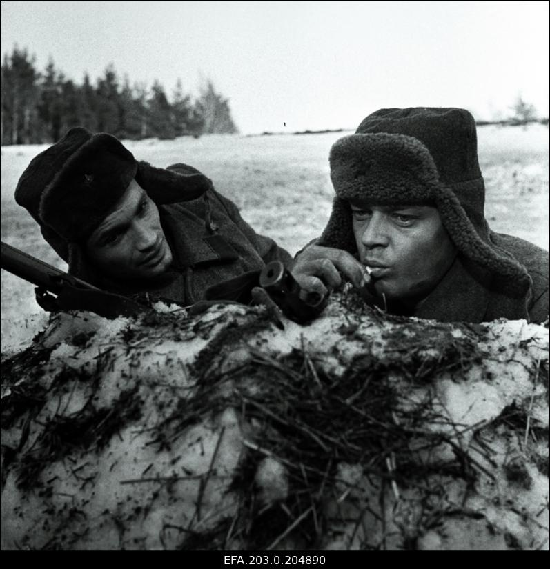 Stseen Tallinnfilmi mängufilmist "Inimesed sõdurisinelis". Lumisel lahinguväljal on sõjamehed (vasakult) Veski (Arvi Hallik) ja Tisler (Rein Juurik).