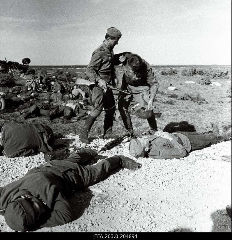 Tallinnfilmi mängufilm "Inimesed sõdurisinelis". Laipu täis lahinguväli. Kalm (Rudolf Allabert) abistab Täägerit (Heino Raudsik).