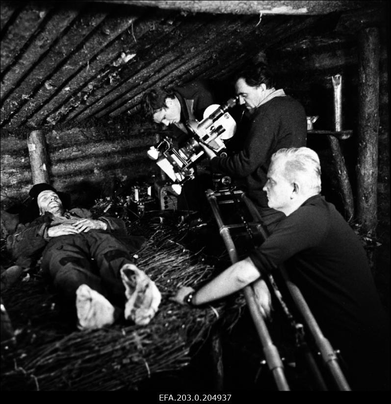 Tallinnfilmi mängufilmi "Inimesed sõdurisinelis" filmivõtted. Barakis lebavat Enn Kalmu (Rudolf Allabert) filmib operaator-lavastaja Mihhail Dorovatovski. Paremal filmi režissöör-lavastaja Jüri Müür.