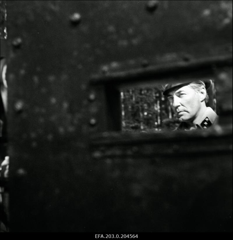 Stseen Tallinnfilmi mängufilmist "Hullumeelsus". Auto tagavaatepeeglis peegeldub Saksa leitnandi (Harijs Liepiņš) nägu.