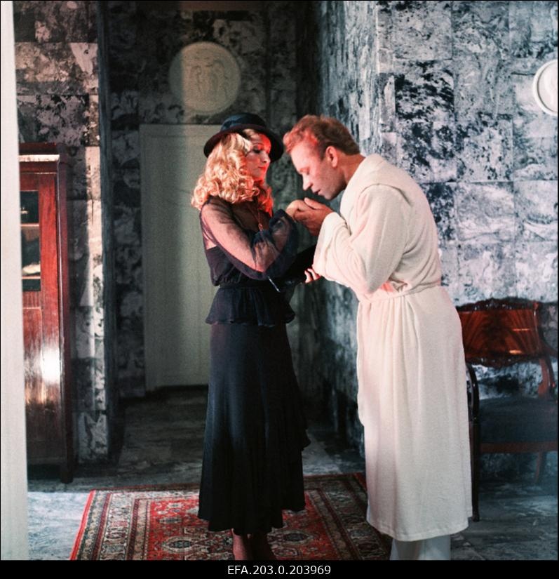 Stseen Tallinnfilmi mängufilmist "Bande". Ned Beamount (Tõnu Kark) suudleb Janet Henry (Mara Zvaigzne) kätt.