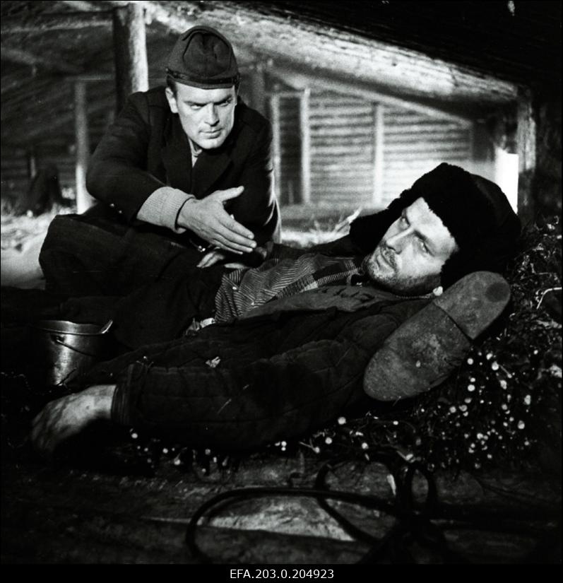 Stseen Tallinnfilmi mängufilmist "Inimesed sõdurisinelis". Reinop (Peeter Kard) püüab Kalmu (Rudolf Allabert) veenda.