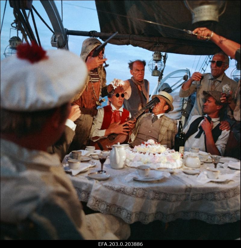 Tallinnfilmi mängufilm "Arabella, mereröövli tütar". Pidulik hetk laeval. Pillimehe (Sulev Luik) kõrval istub härra (Rafail Beltšikov), nende taga Lahja Adam (Endel Pärn) ja Hea Wilhelm (Georg Janson).