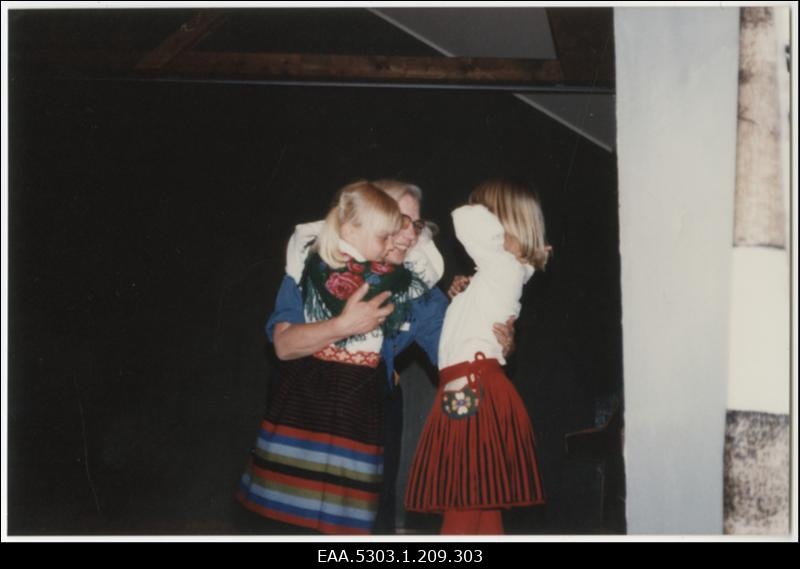 Pärnu lipkonna Mini-Esto, laval skaudijuht, keda õnnitlevad kaks väikest rahvariides tüdrukut