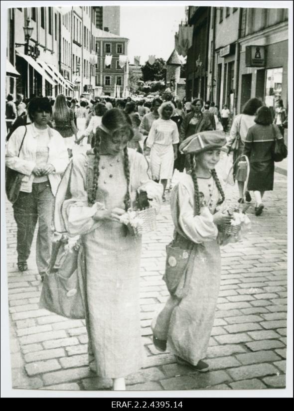 Pilte Tallinna Vanalinna päevadest, rahvas liikumas Viru tänaval, esiplaanil noored tänavakauplejad.