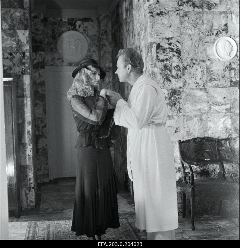 Stseen Tallinnfilmi mängufilmist "Bande". Ned Beamount (Tõnu Kark) suudleb Janet Henry (Mara Zvaigzne) kätt.