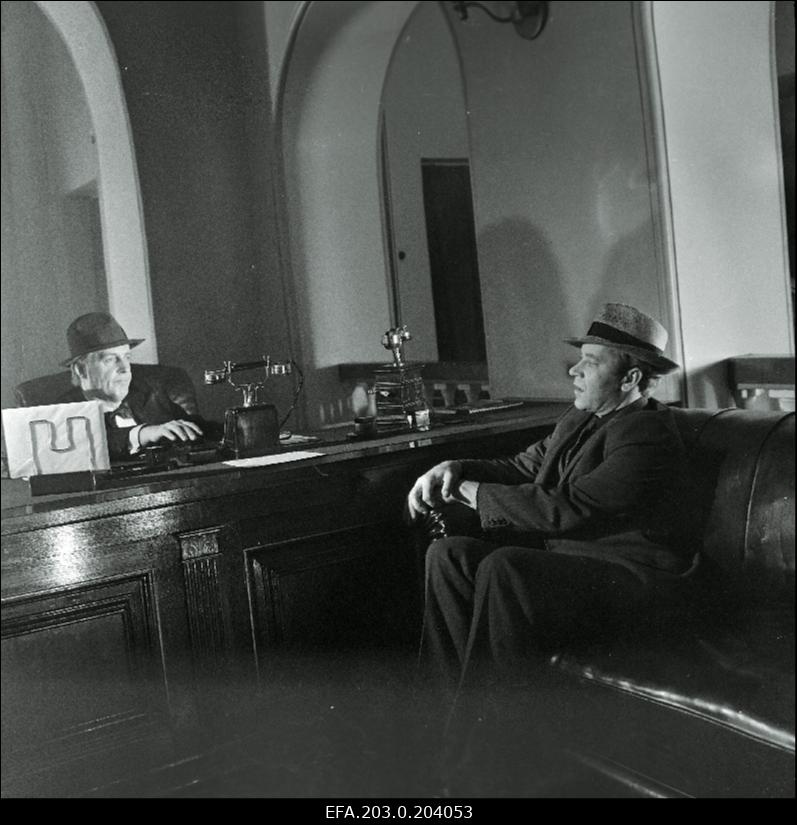 Stseen Tallinnfilmi mängufilmist "Bande". Istuvad Paul Madving (Aarne Üksküla) ja Ned Beamount (Tõnu Kark).