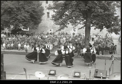 Rahuretk mootorlaeval "Laine" külastamas Saaremaal laulu-ja tantsupidu Kuressaares, tantsijad ja publik linnuse taustal  similar photo