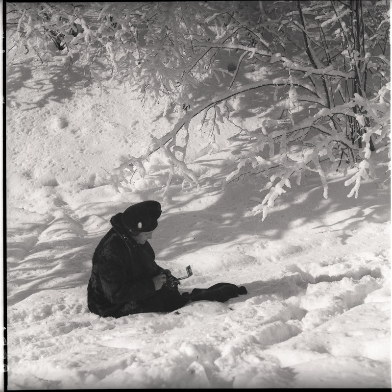 Johanna Triefeldt fotokaameraga lumel istumas