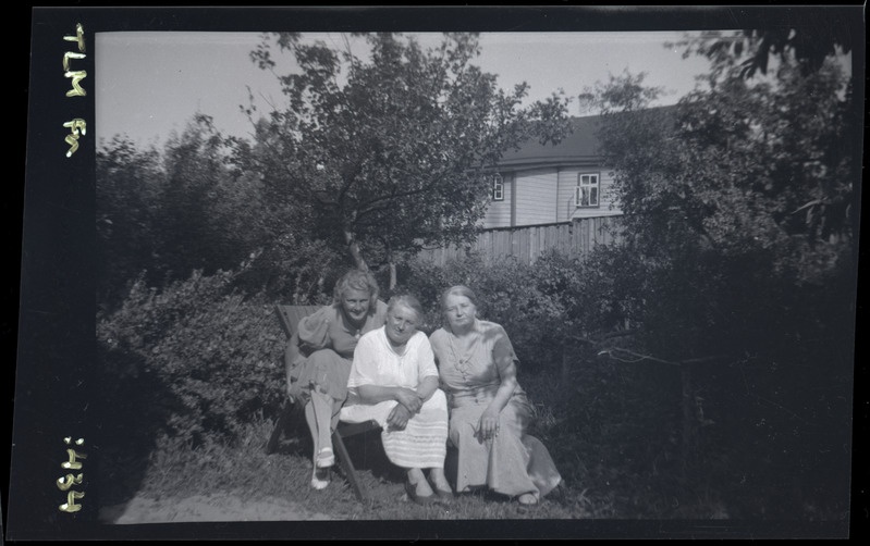 Grupipilt: kolm naist aias marjapõõsaste kõrval