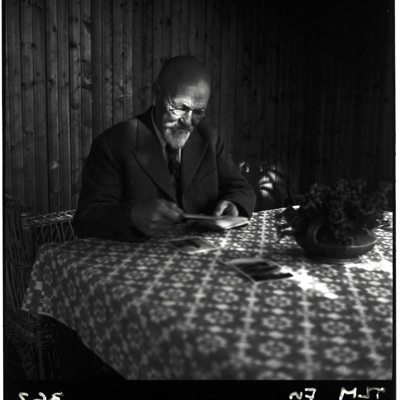 Carl Sarapi onu Aleksander Martin Saar laua taga fotosid vaatamas